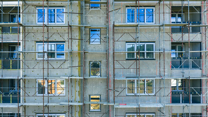 Close-up of building facade with scaffolding and windows during renovation, detail of urban architecture maintenance work