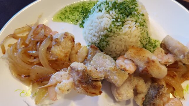Steamed white fish served with caramelized onions and rice with basil sauce. High quality 4k footage