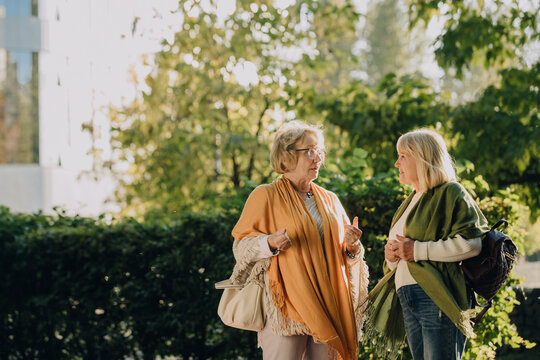 Two senior women talking and enjoying a walk in the park