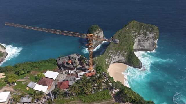 Large construction crane dominates the famous coastal landscape of Kelingking Beach