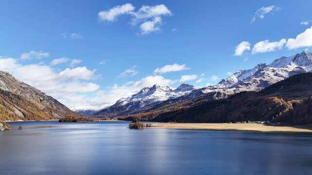 majestic view of lake silvaplana surrounded by snowy peaks and autumn forests in the engadin valley switzerland