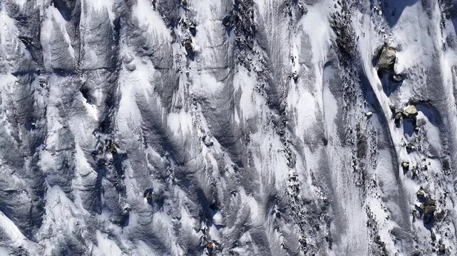 top down view steep snowy alpine slopes and rocky ridges in engadin valley switzerland - drone