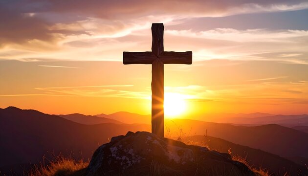 Wood cross on a rocky peak with a radiant golden sunset and mountain range silhouette backdrop