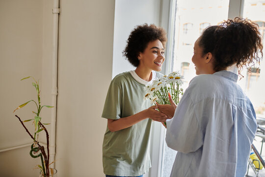 Joyful African American couple sharing moments at home in a vibrant apartment - Powered by Adobe