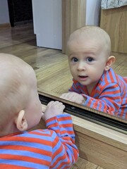 Adorable baby engaging in crucial tummy time while exploring his reflection.

