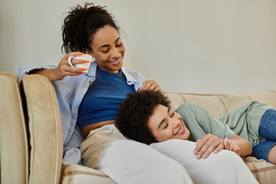 Enjoying quality time at home, a joyful couple shares laughter and warmth on the couch