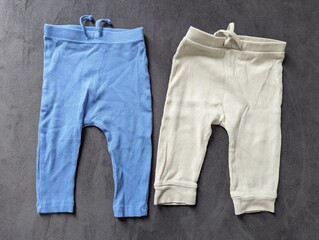 Tiny baby pants laid out on a soft blanket for a newborn. Essential clothing for the first months.

