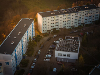 Aerial view of neat rows of buildings and parked cars casting long shadows under the warm glow of the late afternoon sun, Gdansk, pomorskie, Poland.