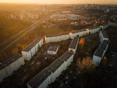 Aerial view of blocky buildings basking in the warm glow of sunset, contrasting against the cool shadows, Suchanino neighborhood, Gdansk, Pomorskie, Poland.