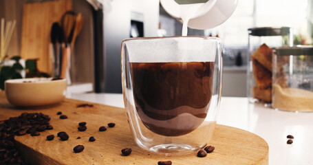 Coffee, glass and milk in kitchen for strong caffeine, pour or roast in home. Organic brew, drink...
