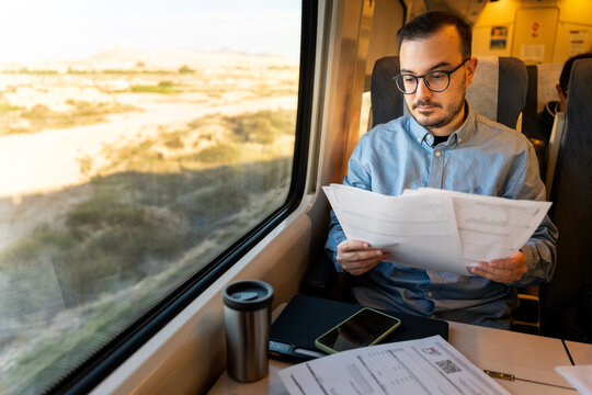 Man working documents during train journey travel