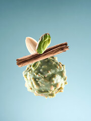 Pistachio truffle with nuts and cinnamon on mint background