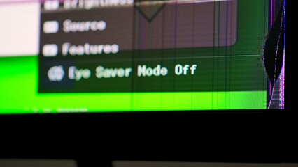 Close up of a cracked television screen showing distorted colors and visible damage, illustrating malfunction.