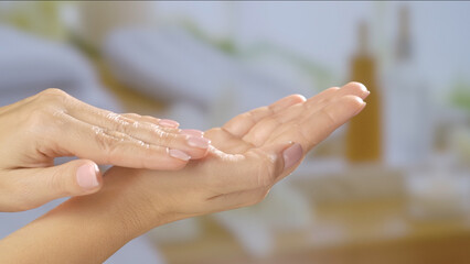 Close up of hands applying moisturizer, focusing on skincare and hydration. Warm, soothing background. Beauty concept, skin care, and cream product presentation.