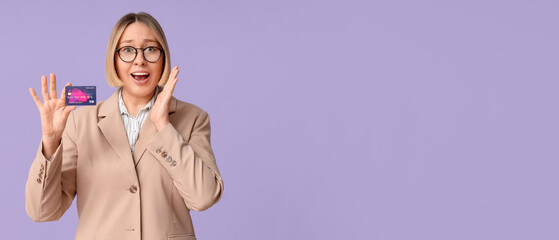 Surprised adult woman with credit card on lilac background