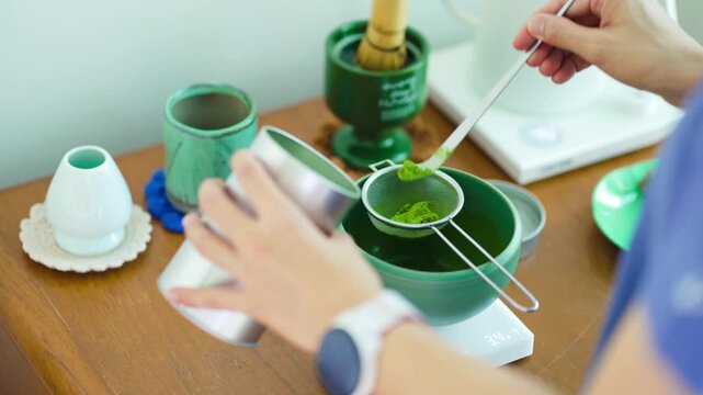Cooking green matcha tea during the Japanese ceremony. Traditiobal kit, Bamboo whisk and beverage, spoon shashaku, heated tea bowl known as a chawan. Horizontal image.