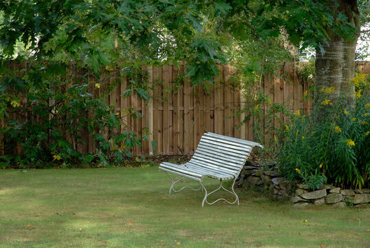 Palissade en bois, Massif en pierre s&eacute;che, Banc de jardin en bois blanc, Pelouse en automne, Verge d'or, Solidago spp, Jardin Malik, Pl&eacute;lan le Petit, 22, C&ocirc;tes-d'Armor, France
