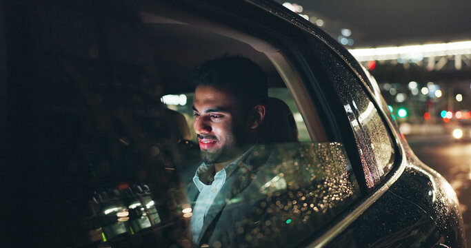 Happy, travel and businessman in car at night in city with networking, email or communication. Smile, technology and male person checking project with deadline in vehicle with commute in urban town.