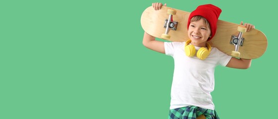 Little boy with skateboard on green background with space for text © Pixel-Shot