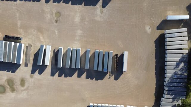 Industrial yard west of Trinity River Trail featuring trailer logistics, semi-trucks, and service vehicles in organized rows beside low-rise buildings and wide paved lots near Loop 12 corridor