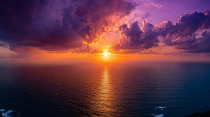 Fototapeta premium Vibrant sunset over ocean horizon creating a dramatic colorful sky with dark clouds and shining water