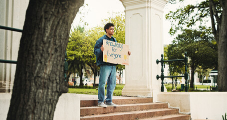 Man, student and campus with poster for protest, education or knowledge of human rights in park. Male person, scholar or academic activist with sign or cardboard for learning development of humanity © PeakCC/peopleimages.com