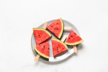 Plate with sweet watermelon sticks on white background