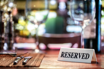 Reserved sign on restaurant table with bar background