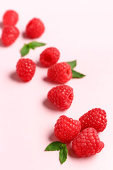 Many fresh raspberries and mint on pink background
