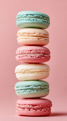 Stack of colorful pastel macarons on pink background Delicious French macarons tower Concept of confectionery, dessert, and sweet treat