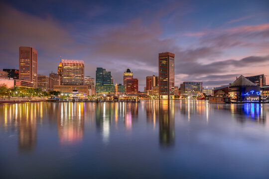 Baltimore, Maryland, USA. Cityscape image of downtown Baltimore, Maryland with reflection of the skyline in the water at beautiful autumn sunrise.