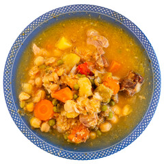 White plate with chickpea soup on dark wooden table. Pieces of meat, bacon, and vegetables are added to soup. Isolated over white background
