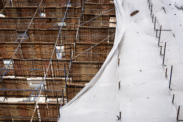Wooden and Metal Scaffolding with Protective Tarp - Facade Renovation in Progress