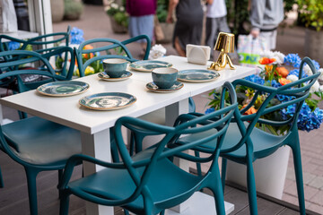 Modern Outdoor Dining Setup at Street  cafe - Teal Chairs and Floral Accents