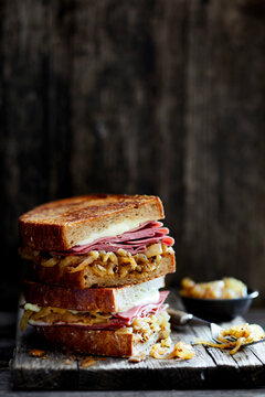 Rustic pastrami sandwich with melted cheese and caramelized onions on artisan bread