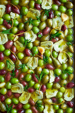 Marinated olives with artichokes, garlic, rosemary, and olive oil top view