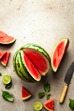 Watermelon with slices on a stone surface