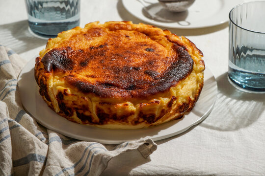 Basque Cheesecake in Natural Sunlight on Linen Tablecloth