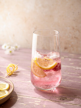 Raspberry lemonade served with ice, lemon slices and fresh raspberries