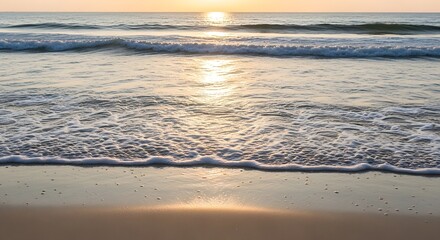 Fototapeta premium Golden hour at the beach with gentle waves and sunlight.