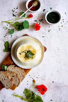 Ricotta with nasturtium, mint, honey, and sourdough bread. Ingredients for breakfast tartine. Negative copy space.