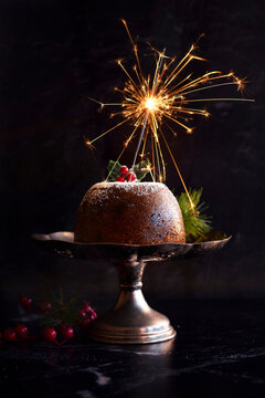 English style festive Christmas plum pudding dessert against black marble background.