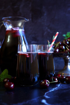 Pure Black Cherry Juice on Dark Background.