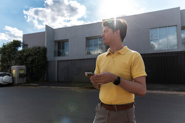 Contemplative urban man with smartphone near modern architecture