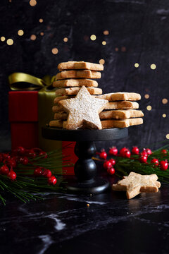 Star shaped shortbread biscuit cookies in festive holiday background setting.