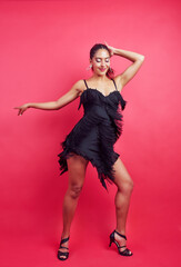 Energetic woman dancing in a black fringe dress, expressing joy