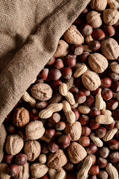 Walnuts, Hazelnuts, Peanuts on a jute background.
