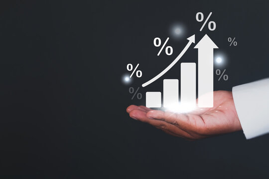 Finance and investment concept. Businessman hand holding holographic bar chart with percentage sign on dark background with copyspace idea for Financial growth, investment return,Business growth.