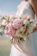 Close-up photo of a woman holding bouquet of beautiful flowers. Bridal concept. Marriage ceremony.
