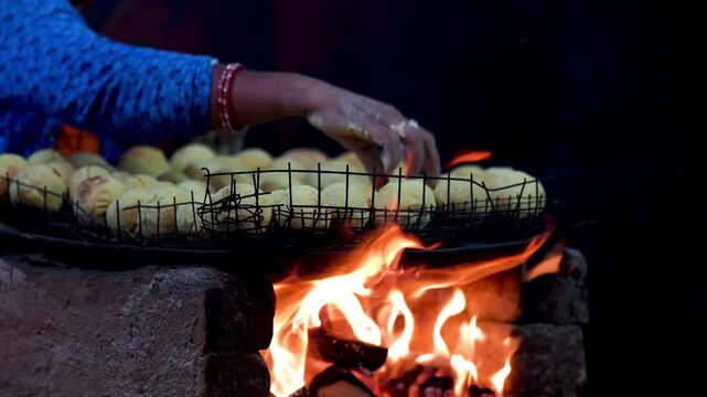 A traditional Indian street vendor making litti chokha on a coal fire. The glowing embers and slow cooking highlight India&rsquo;s authentic village cuisine.